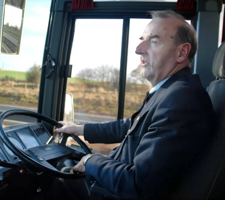 Professional coach driver in uniform driving modern coach