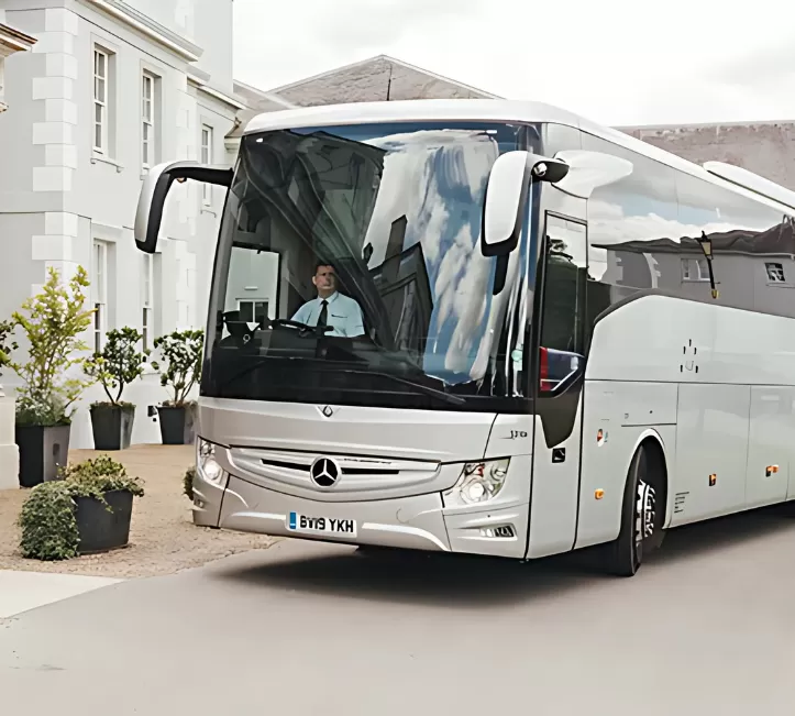 A Stewarts luxury coach parked outside a hotel building.